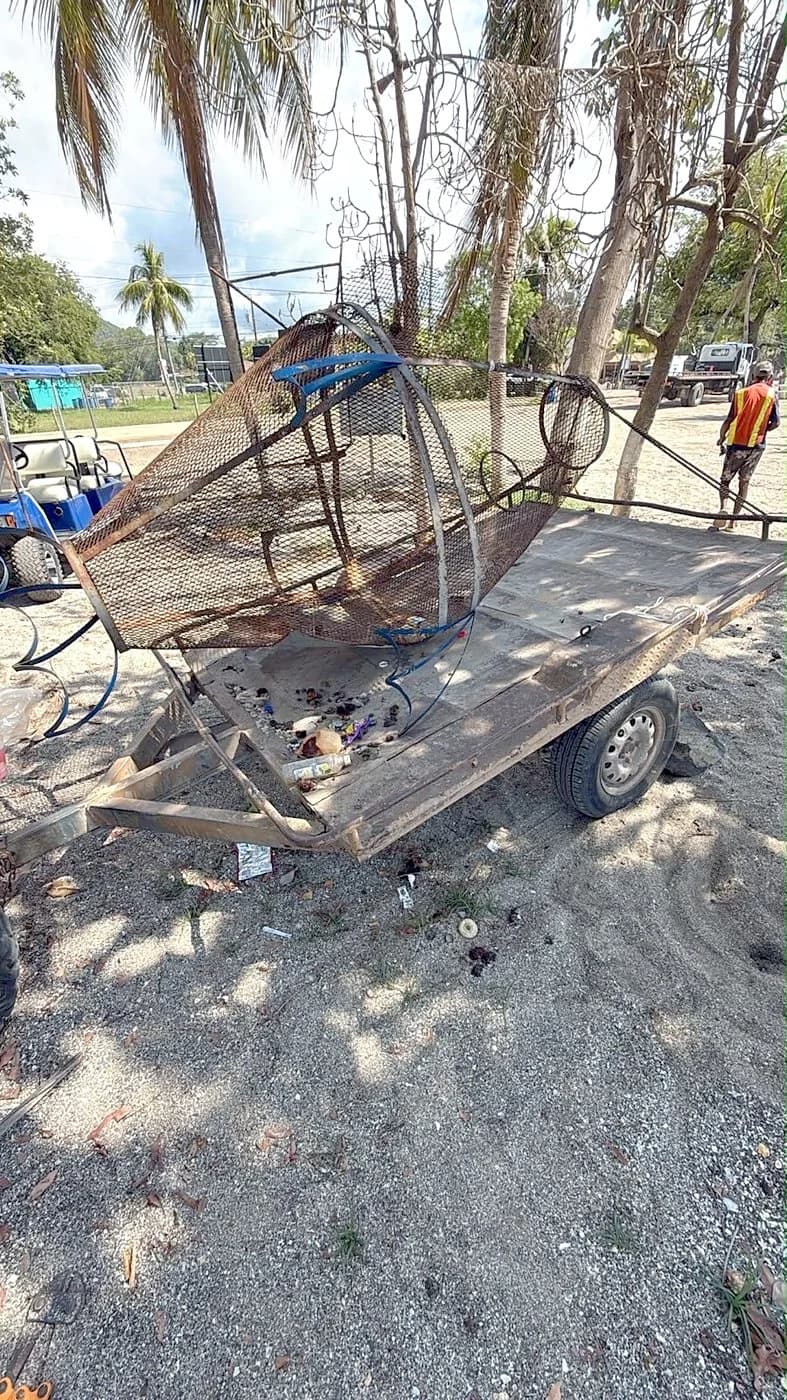 Rusted trash bin loaded on a trailer for removal